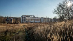 ein fein strukturiertes Fabrikgebäude in grüner Landschaft